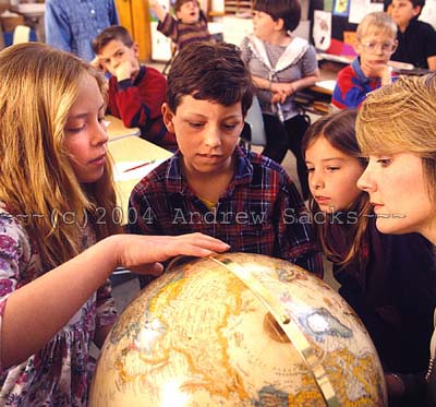 Elementary teacher shows students globe