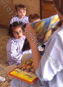 Pre-school teacher reads to class (Spain)