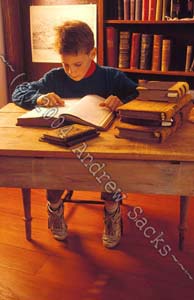 Boy reads antique books in library