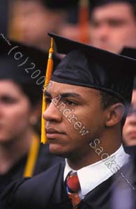 Robed college grad in thoughtful moment