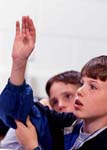 Boy raises hand in classroom
