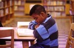Boy studies alone in library