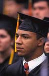 Robed college grad in thoughtful moment